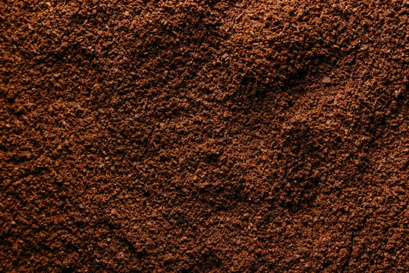 Detailed close-up image of freshly ground coffee showcasing rich brown texture