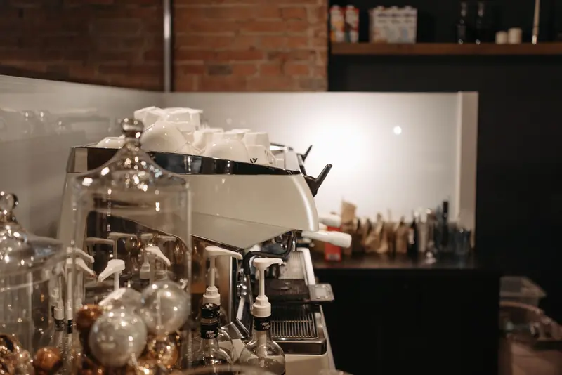 A cozy coffee shop interior featuring a modern espresso machine and various coffee accessories