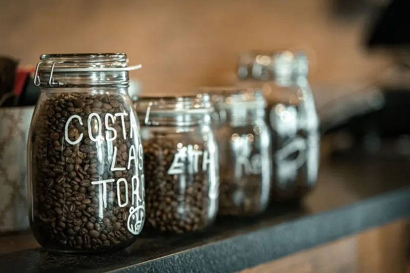 Close-up of labeled glass jars filled with coffee beans on a countertop in Bursa, Türkiye