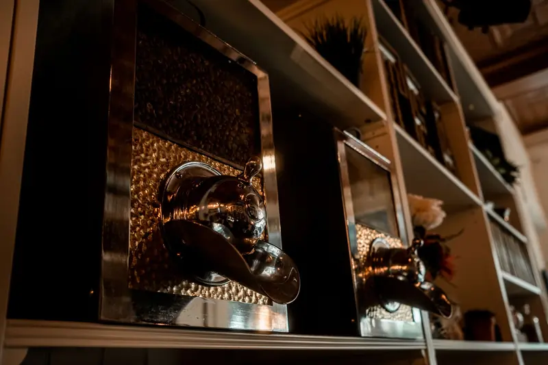 Stylish coffee dispensers on a shelf in a cozy café setting, illuminated warmly