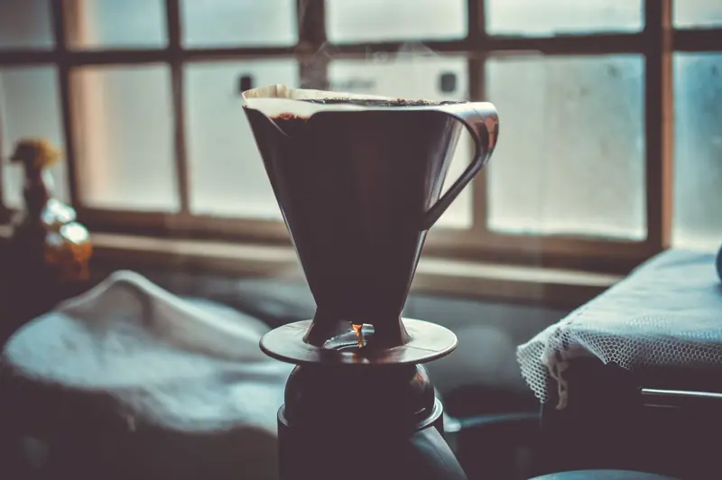 A serene setup of a pour over coffee maker with a window backdrop, creating a cozy morning vibe