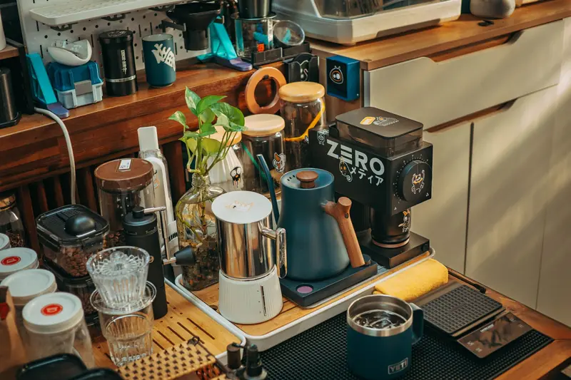 A detailed coffee station setup featuring grinders, mugs, and brewing tools in a cozy indoor setting